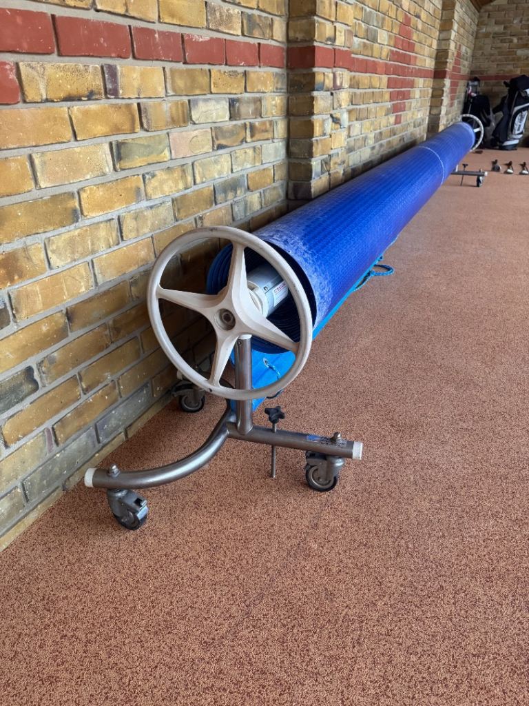 Swimming pool protective cover with roller