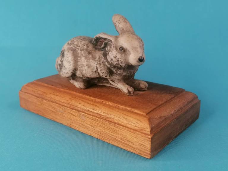 Vintage Ceramic Rabbit laying on wood. As seen.