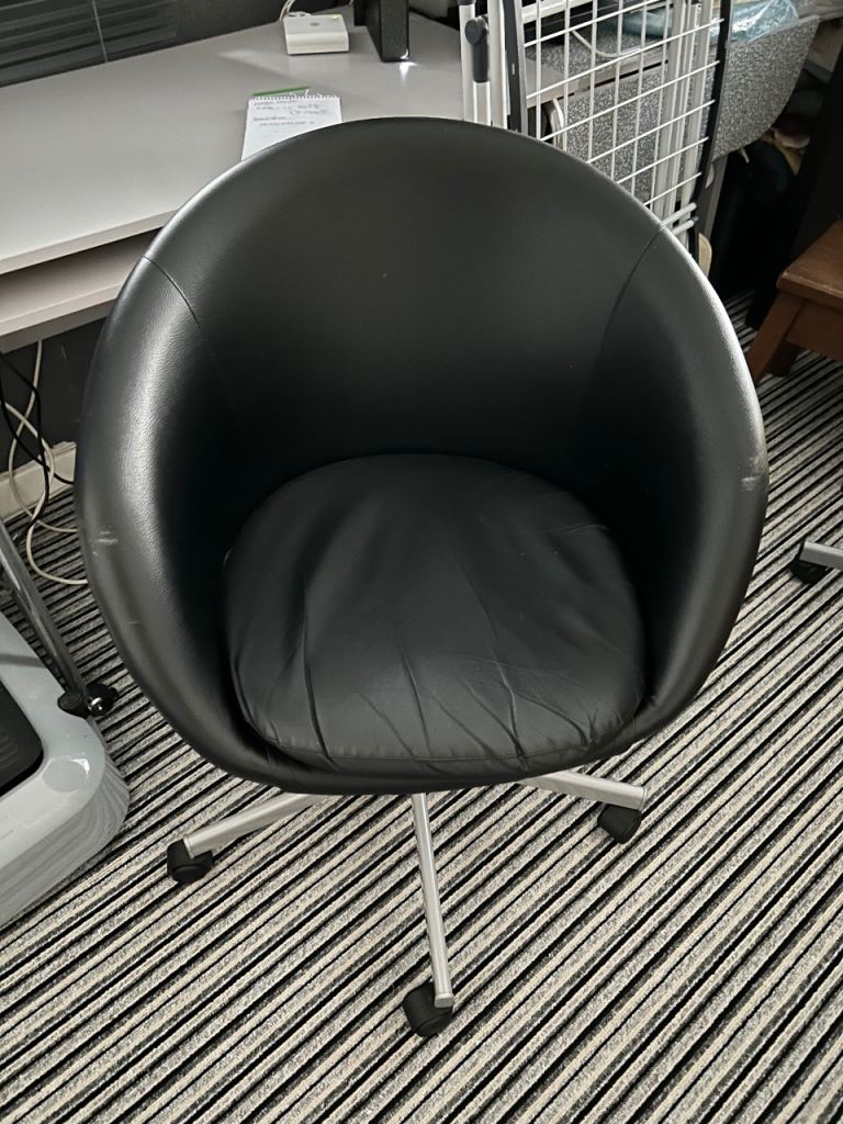 Black swivel tub chair on wheels. 