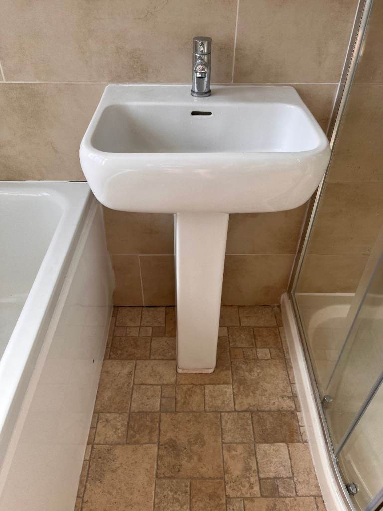 White Bathroom Suite: Toilet, Sink, and Cabinet