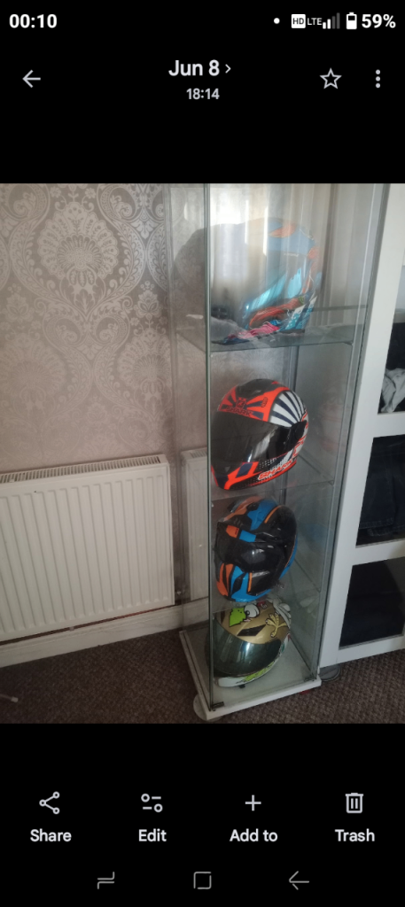 4 crash helmets in display cabinet 