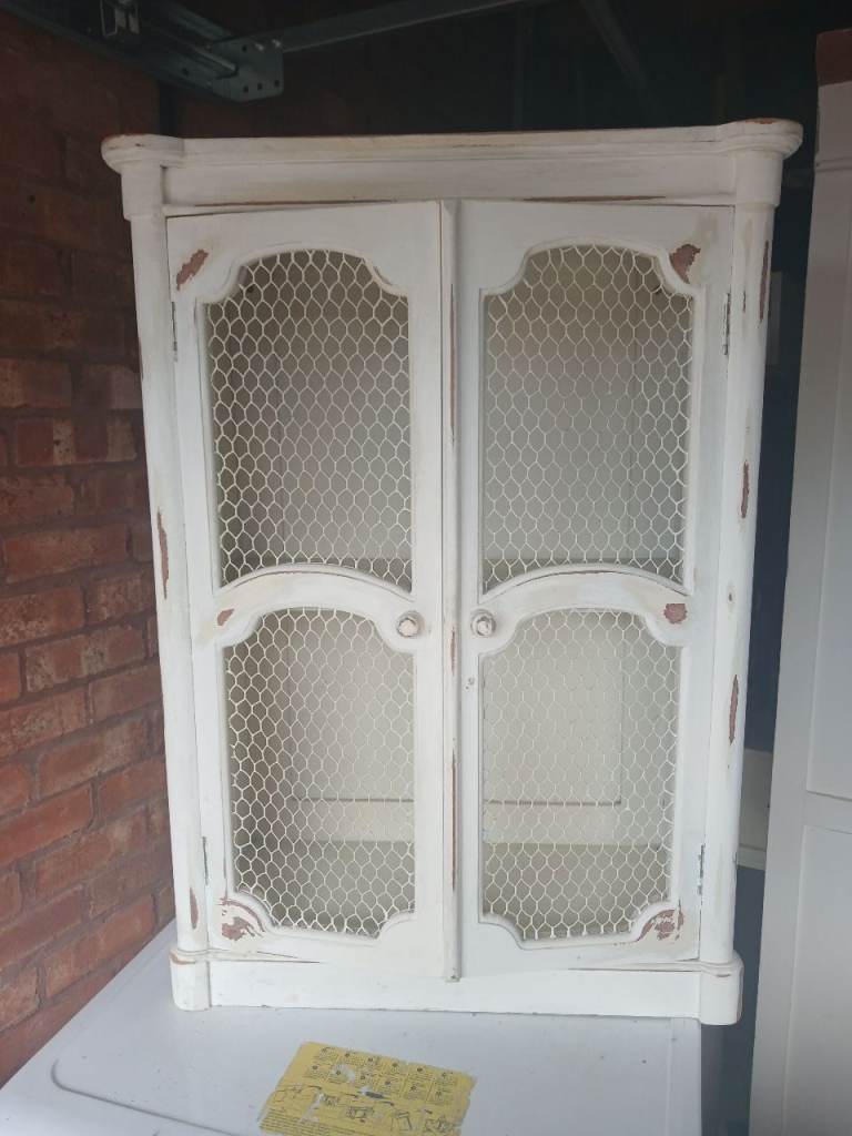 Charming White Distressed Wall Cabinet with Chicken Wire Doors