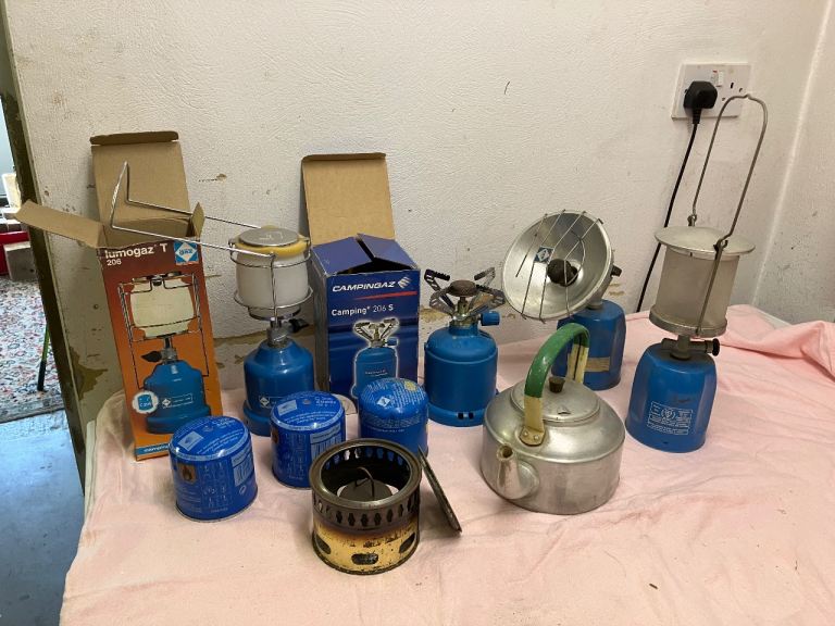 Collection of camping lights and stoves including vintage tent.