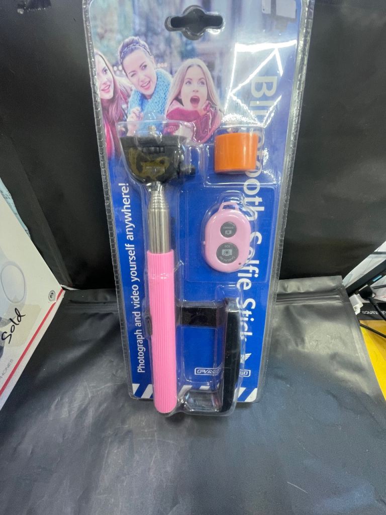 Pink Bluetooth selfie stick with remote.
