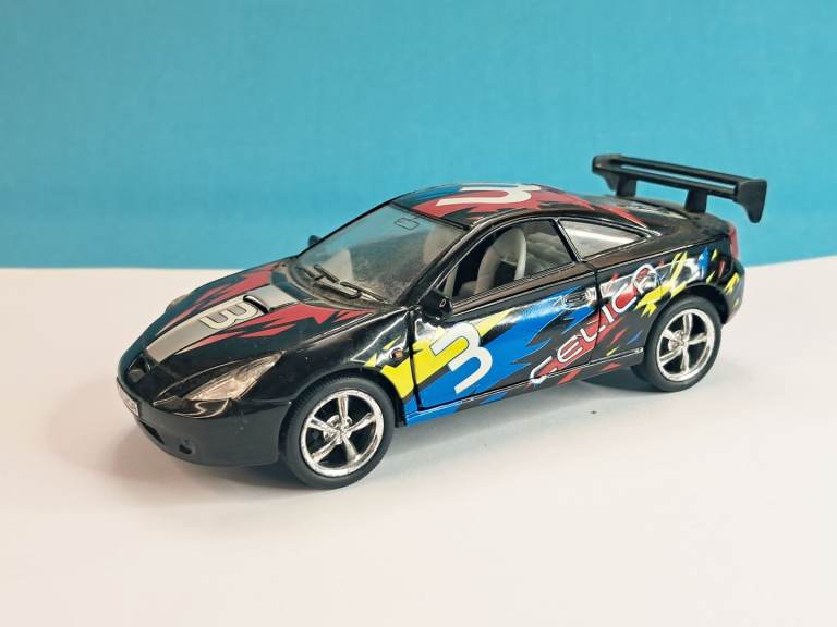 Kinsmart diecast 1:34 scale Toyota Celica model car in black with racing decals.
