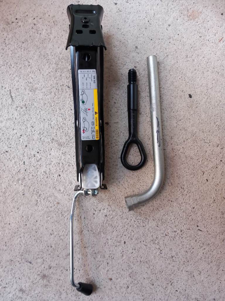 New car jack with wheel spanner and towing eye. 