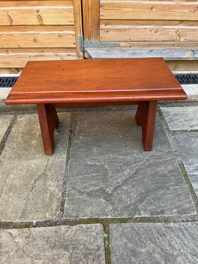 A small wooden stool /bench with nicely shaped legs.