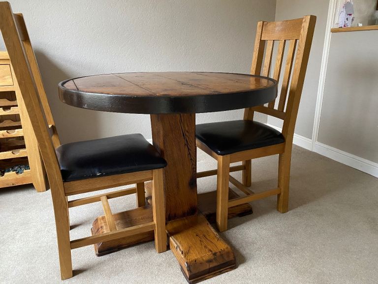 Oak circular dining table and two chairs