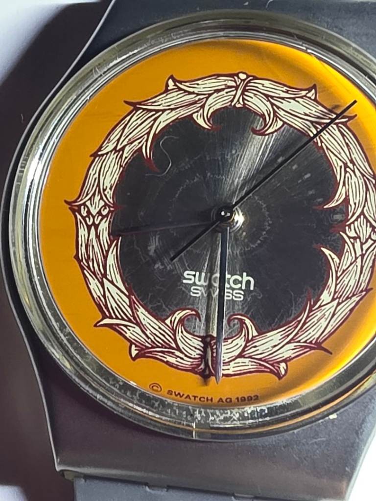 Swatch Gent watch with a gray band and case, featuring a graphic design Working