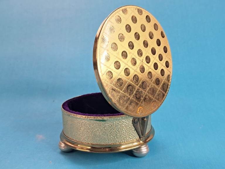 Vintage gold-toned And brass footed trinket box with a purple velvet interior.