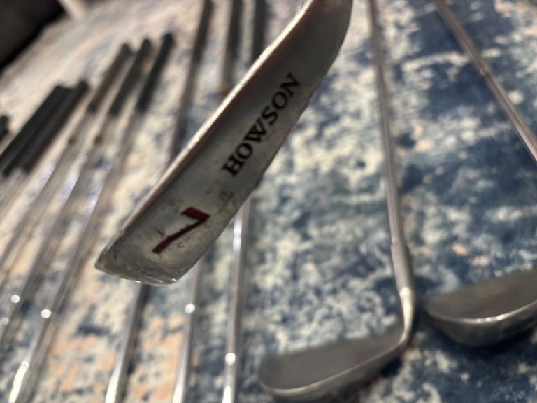 A bunch of right handed golf clubs 