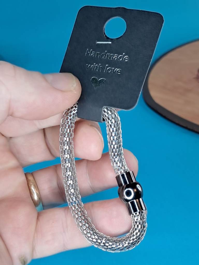 This is a silver-toned mesh bracelet with a magnetic clasp. Hand made  with love. New.