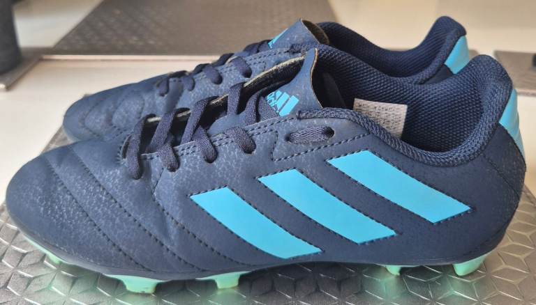 Adidas Goletto VII junior firm ground football boots in a navy blue and light blue colorway size 3