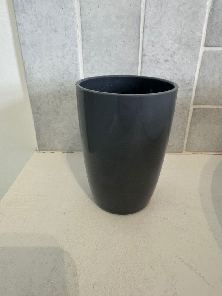 Grey plastic toothbrush holder