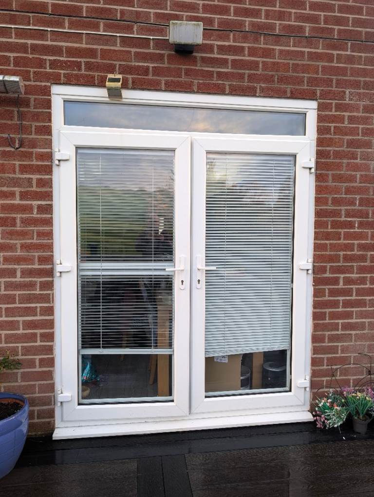 External double french doors with frame, key, cill and blinds.