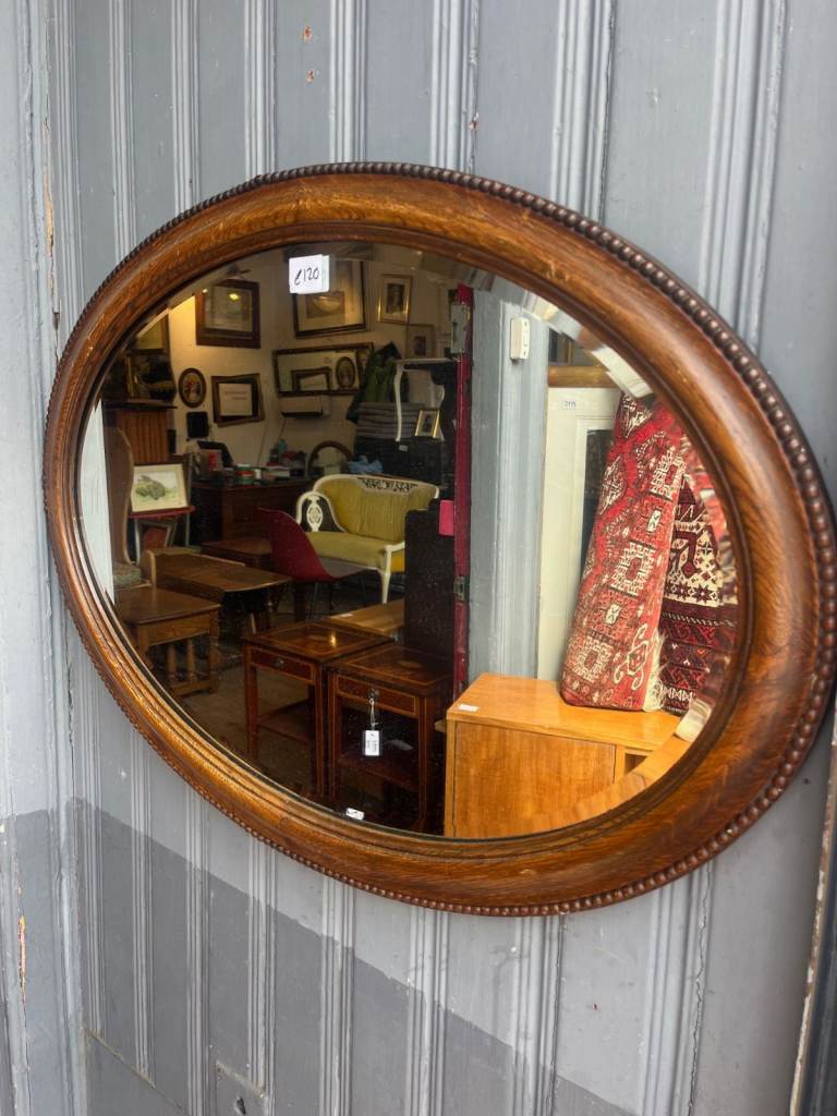 Mahogany Framed Oval Mirror , has lovely carved detail . Bevelled glass