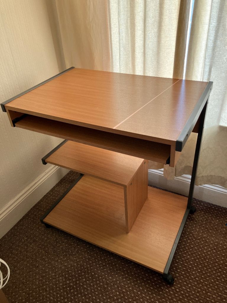 Computer desk on wheels with pull-out tray.