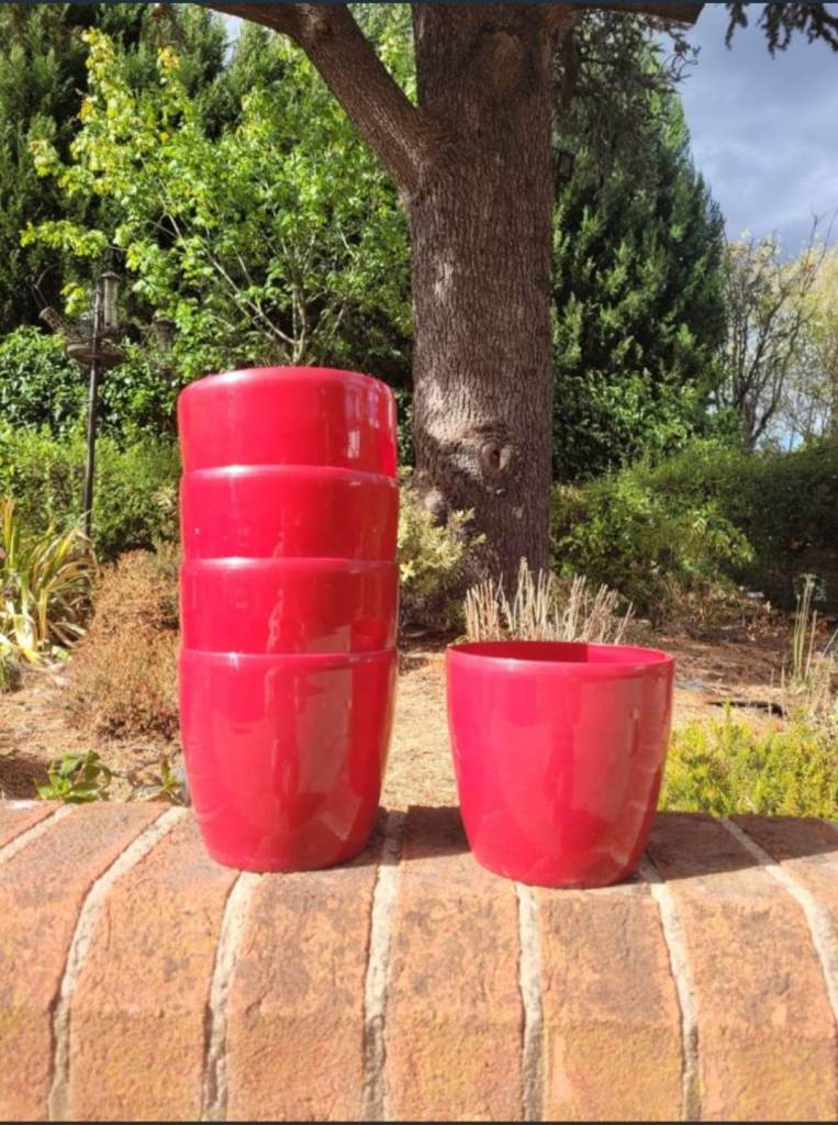 5 small plastic red plant pots in good condition