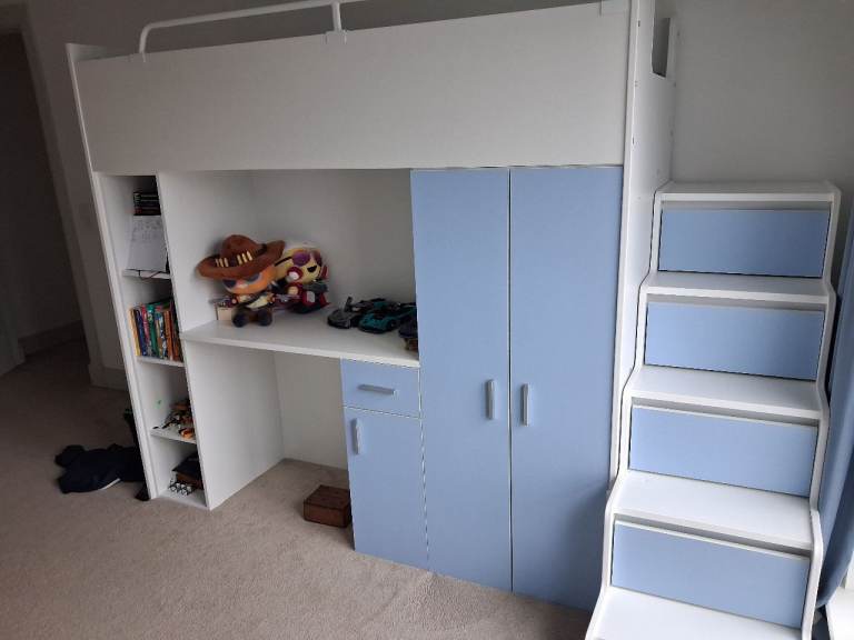 Boy's bed with storage units and a desk. 