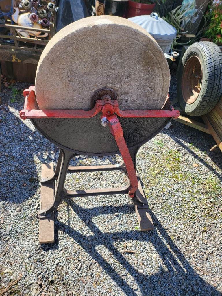 Old sharpning stone on a stand garden decoration 