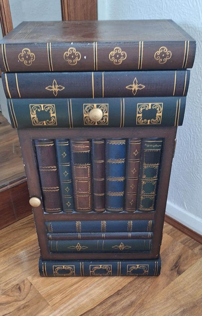 Wood antique cabinet made to resemble a pile of old books,