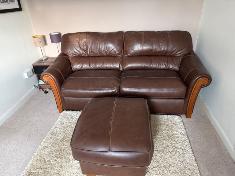 Brown leather sofa bed and footstool
