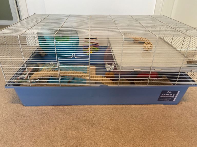 Cage, accessories, sawdust, treats & label with measurements 