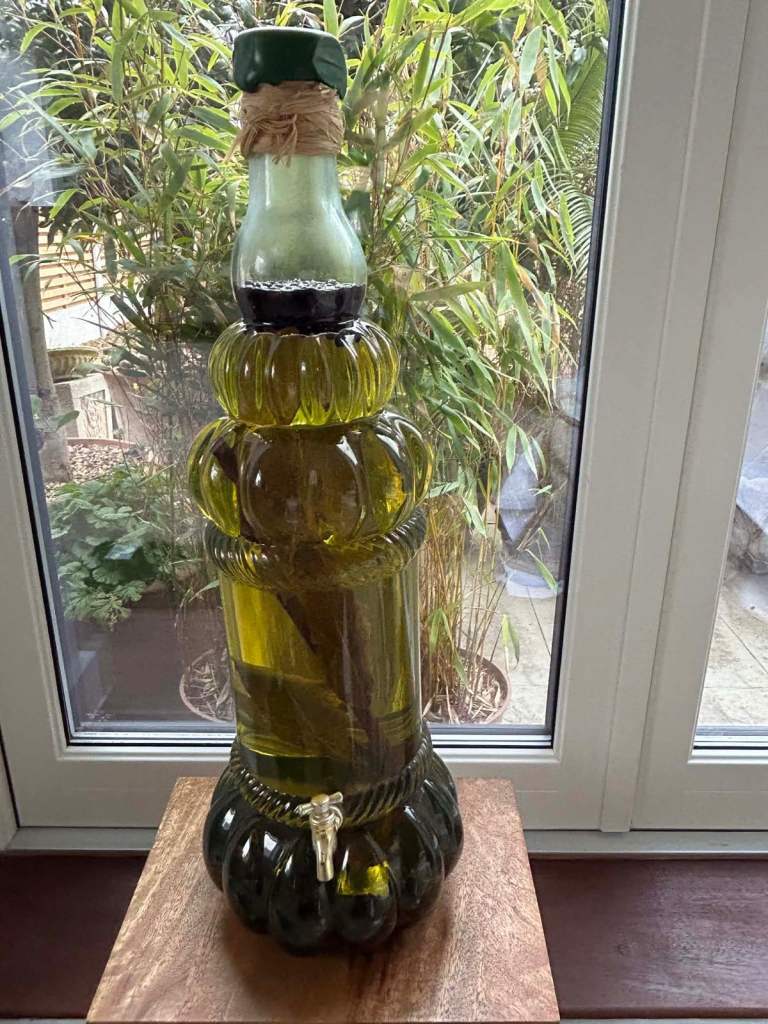 Glass oil storage jar display with tap. 
