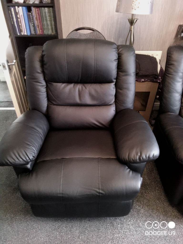Two black faux leather recliner chairs 
