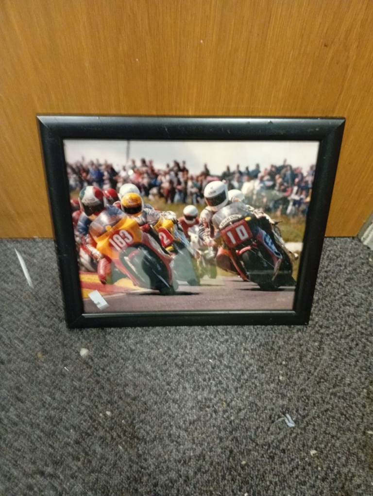 This framed photograph depicts a motorcycle racing scene,