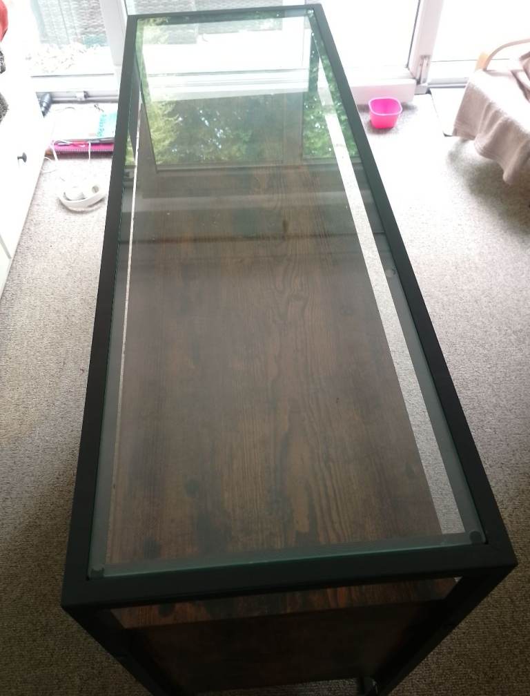 Side board , dark colour , glass top 