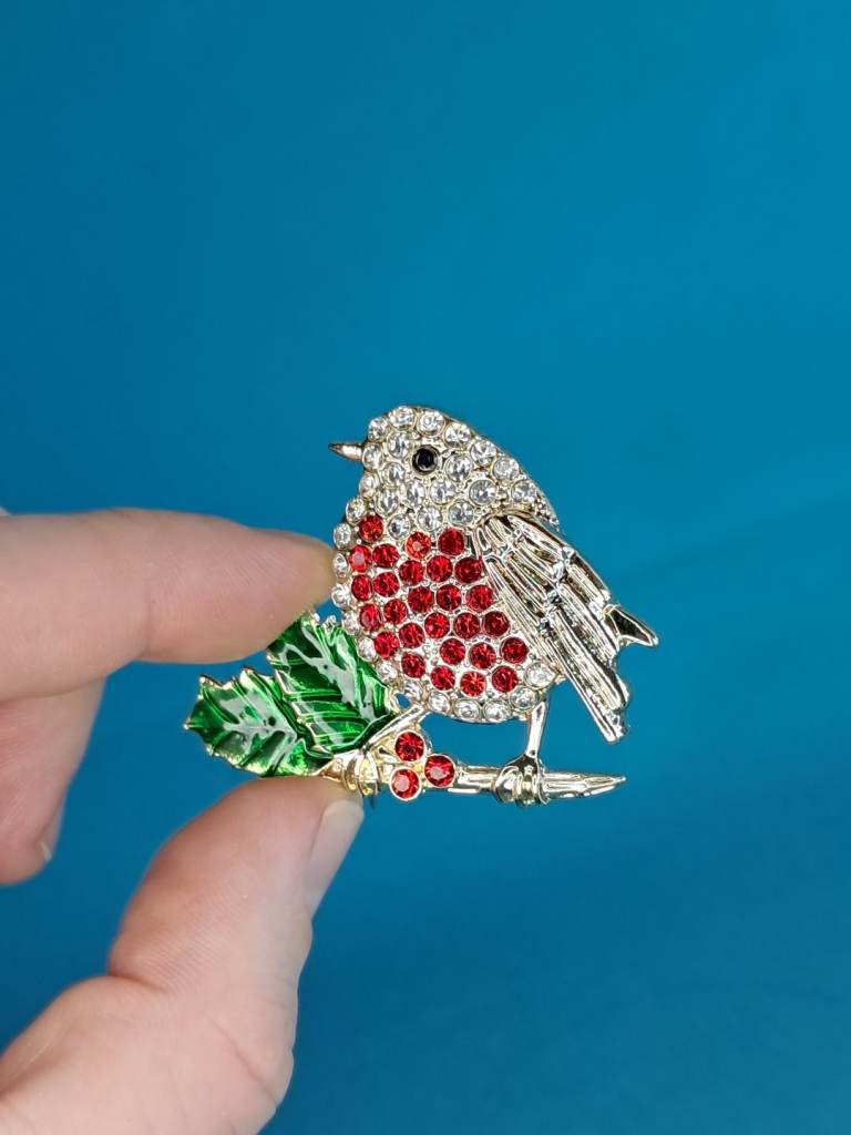gold-toned robin brooch with shimmering red and clear crystals.