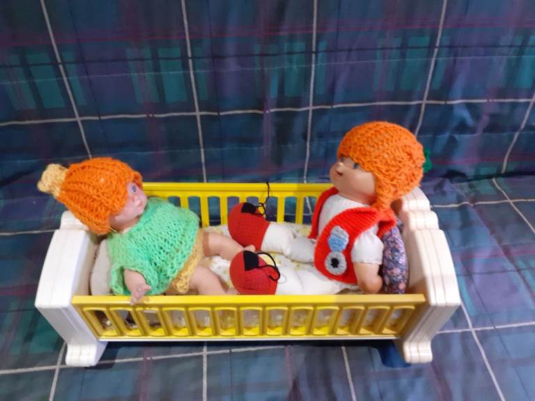 Musical dolls' cot with two dolls