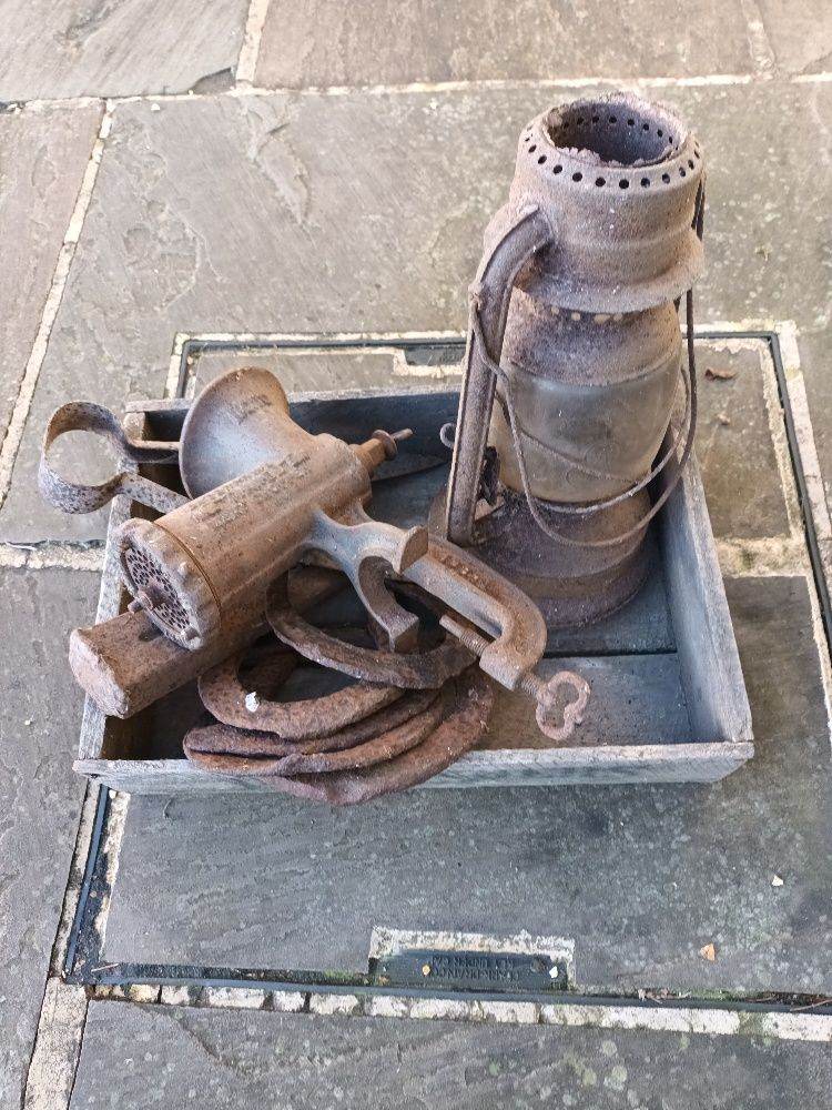 Old iron farm items.  Oil lamp, horse shoes, Mincer, wool cutters in old wood box