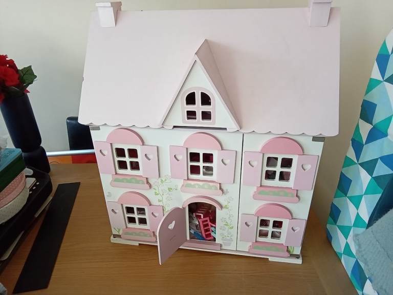 Large dolls house with lots of furniture. 