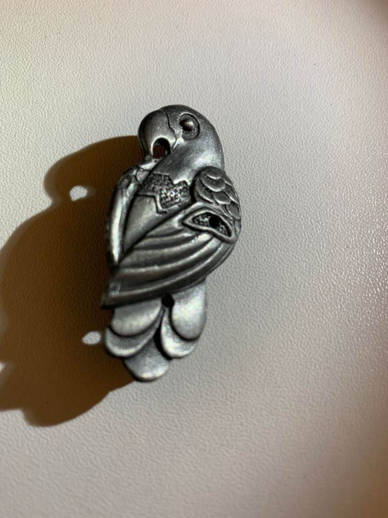 This vintage jewellery set features a charming pewter parrot design