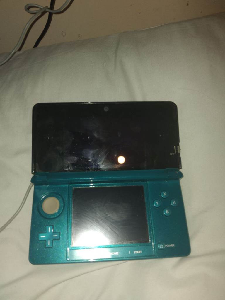 cyan nintendo 3ds paired with 8 games