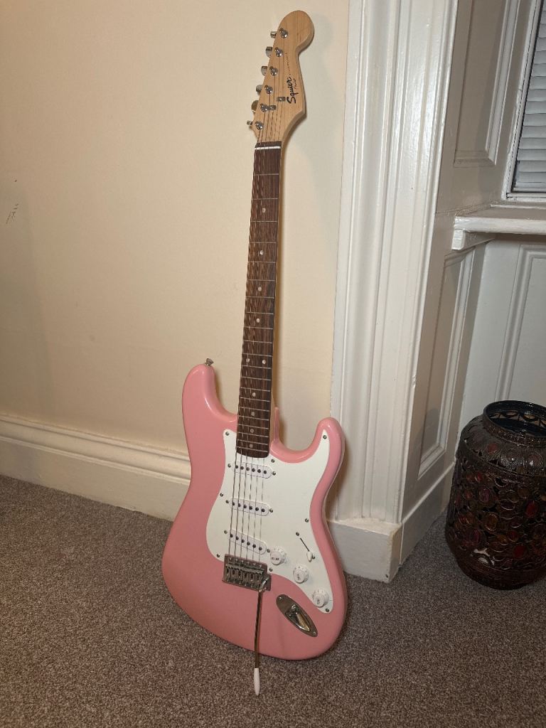 Squier by Fender Mini Stratocaster electric guitar in a shell pink finish.
