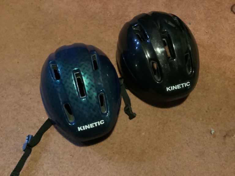 A pair of Kinetic Cycle Safety Helmets