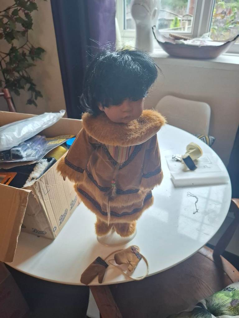 Traditional Eskimo doll on stand in fur coat