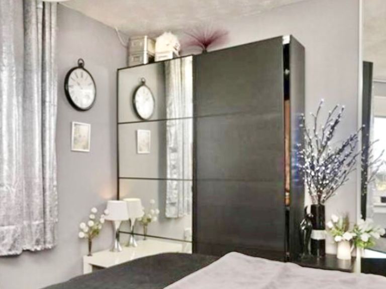 Black mirrored Ikea wardrobe with hanging space and drawers, good condition, been in guest room