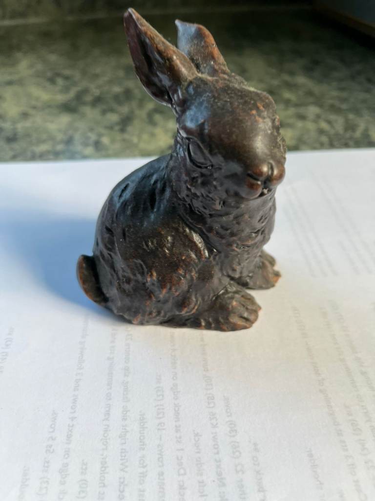 A small ornament 0f a brown rabbit possibly made from resin.