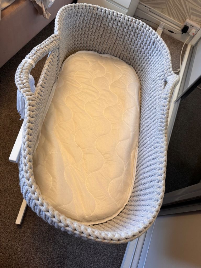 Light grey crochet crib with white wooden stand 