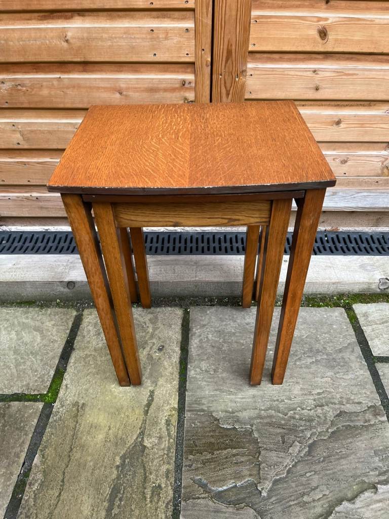A nest of two wooden tables with square legs.