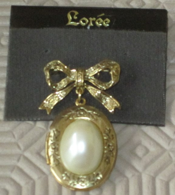 'LOREE USA' VINTAGE GOLD TONE BROOCH, BOW DANGLING OVAL PEARL LOCKET, OPENS, NEW NEVER WORN