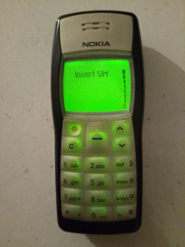 Nokia 1100 simple mobile phone with charger and original instruction manual