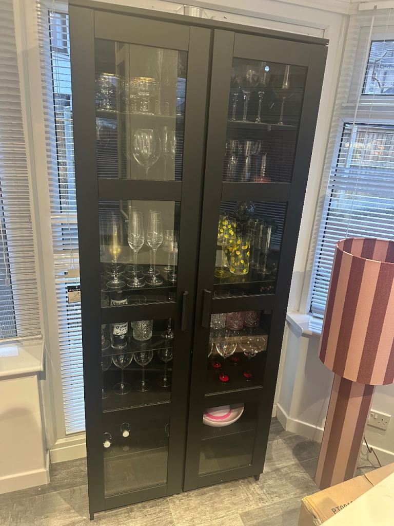 Tall black Ikea display cabinet with glass shelving double doors