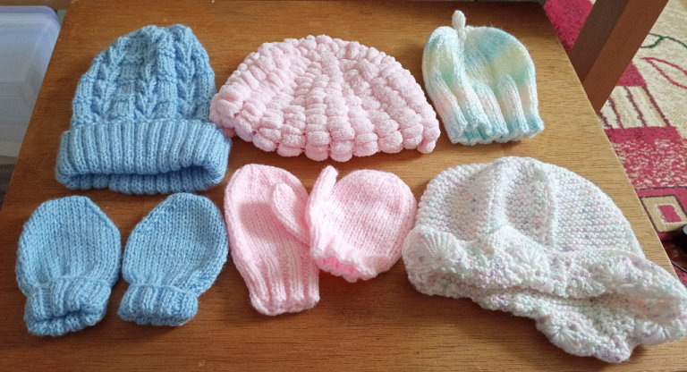 Selection of hand knitted baby bonnets & mittens (postage available)