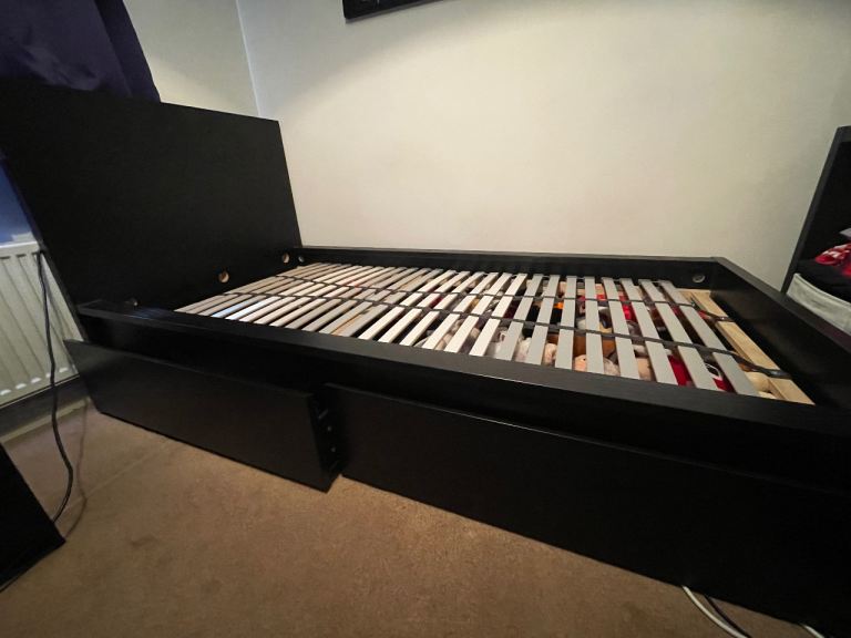 Black Malm Ikea single bed with storage drawers on wheels and fixed slatted base