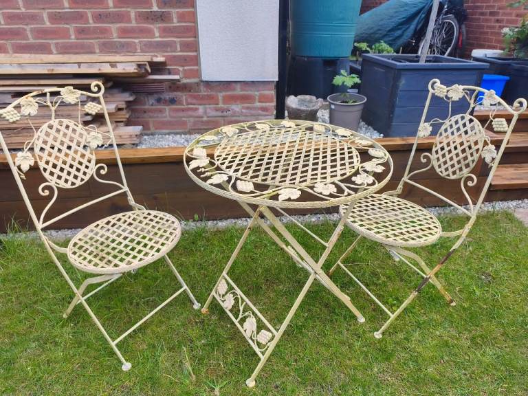 Metal bistro set features intricate grape leaf details and foldable construction